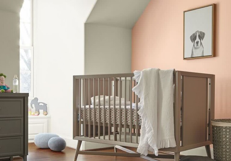 dormitorio bebé, cuna beige, paredes blancas y rosa salmón
