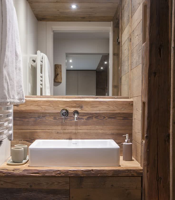 baño con paredes y encimera de madera rústica