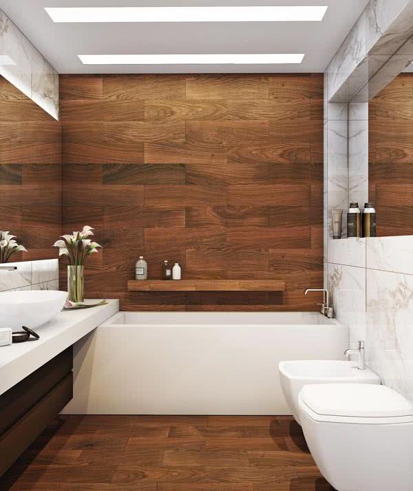paredes y suelo con cerámicos imitación madera, bañera blanca y encimera blanca