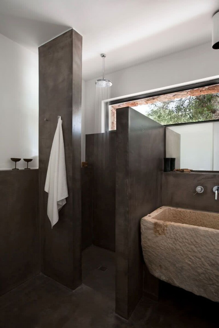 ducha con paredes de microcemento, lavabo de piedra