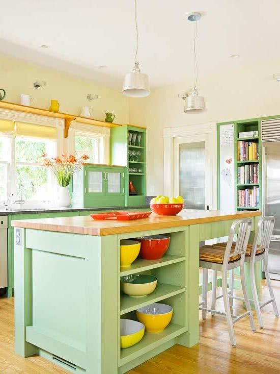 cocina con isla en color verde, encimeras de madera, paredes amarillas