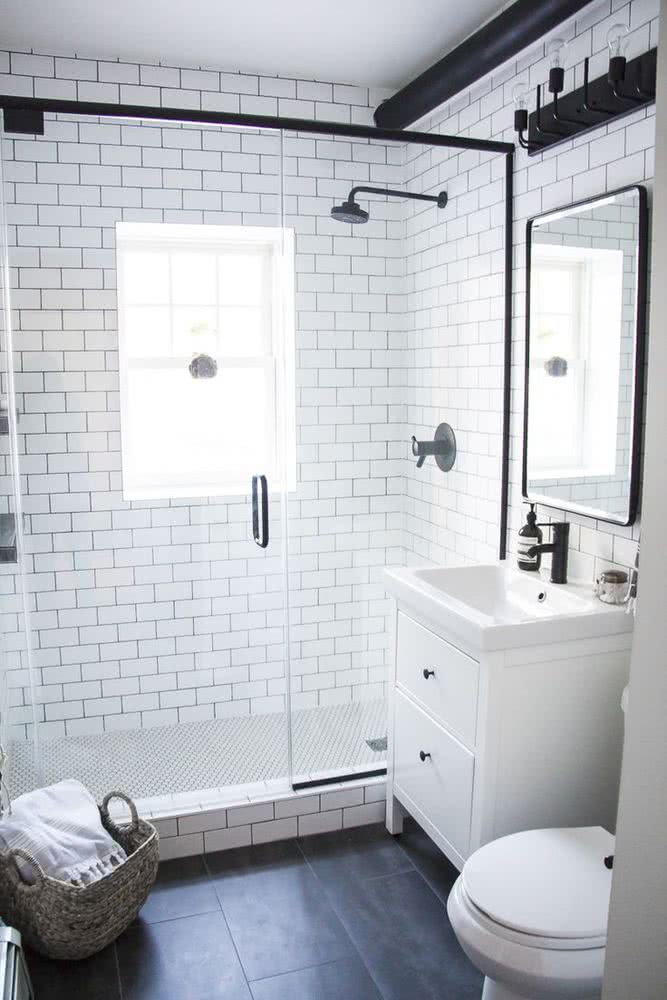 baño con ducha, azulejos rectangulares blancos, pequeño mueble con lavabo