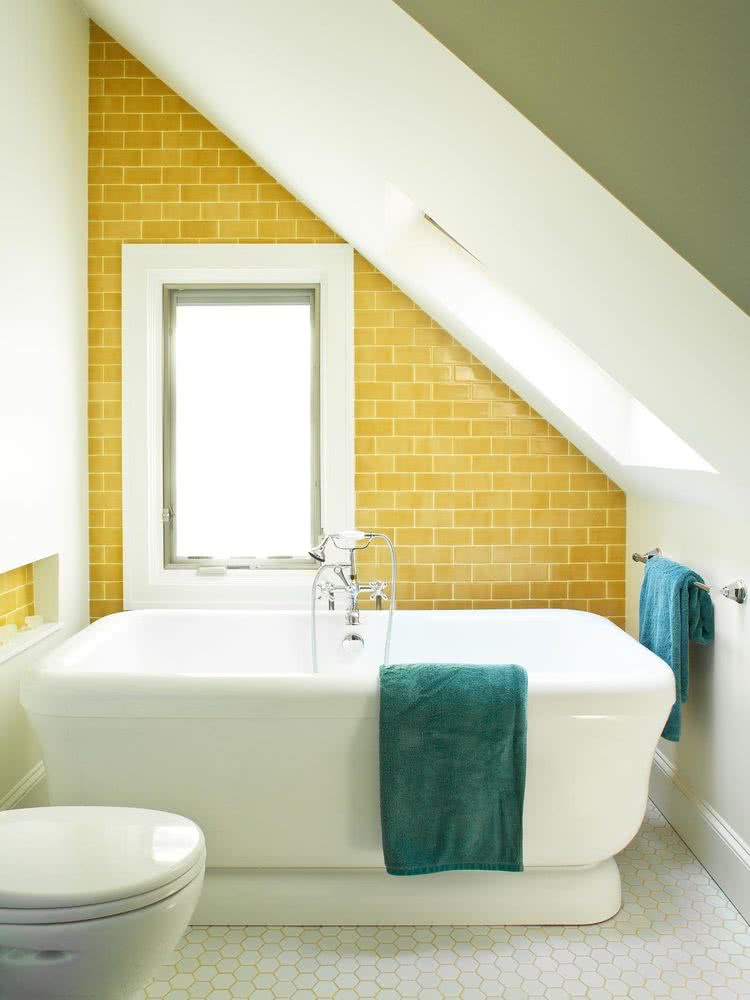 bañera blanca con pared posterior con azulejos amarillo