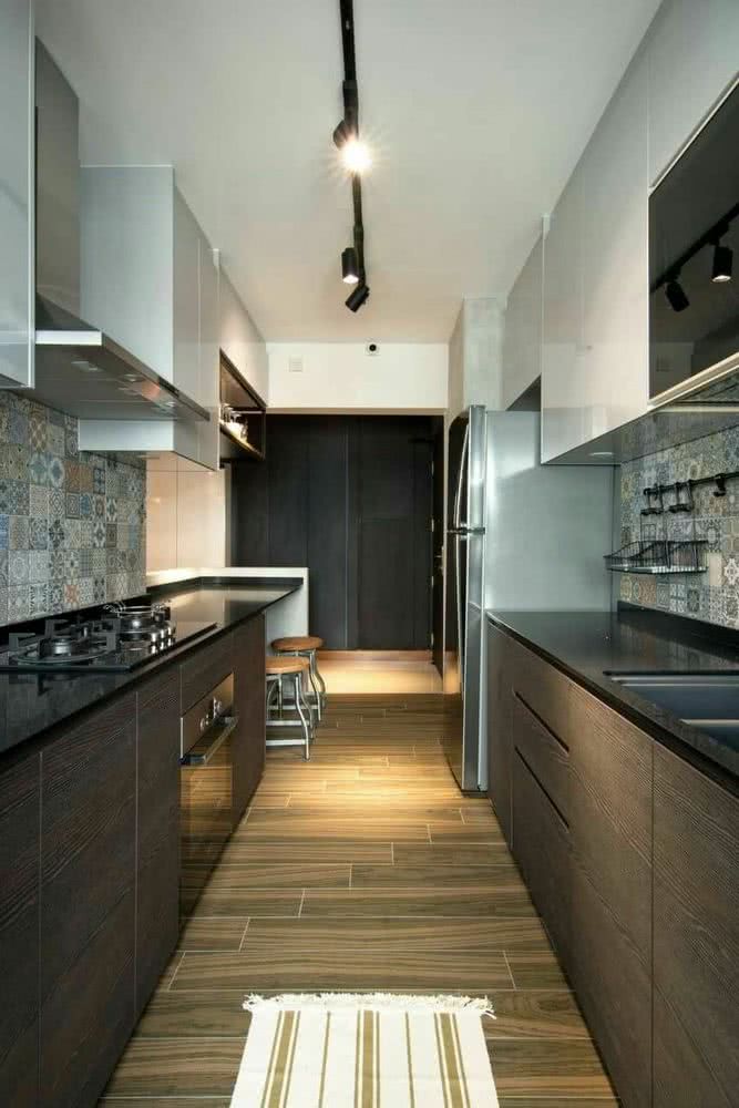 cocina alargada en dos paredes, encimera negra, muebles bajos en madera, armarios altos blancos