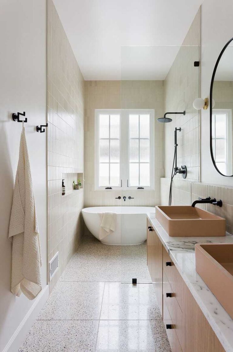 baño alargado con paredes blancas, suelo de terrazo, muebles en madera